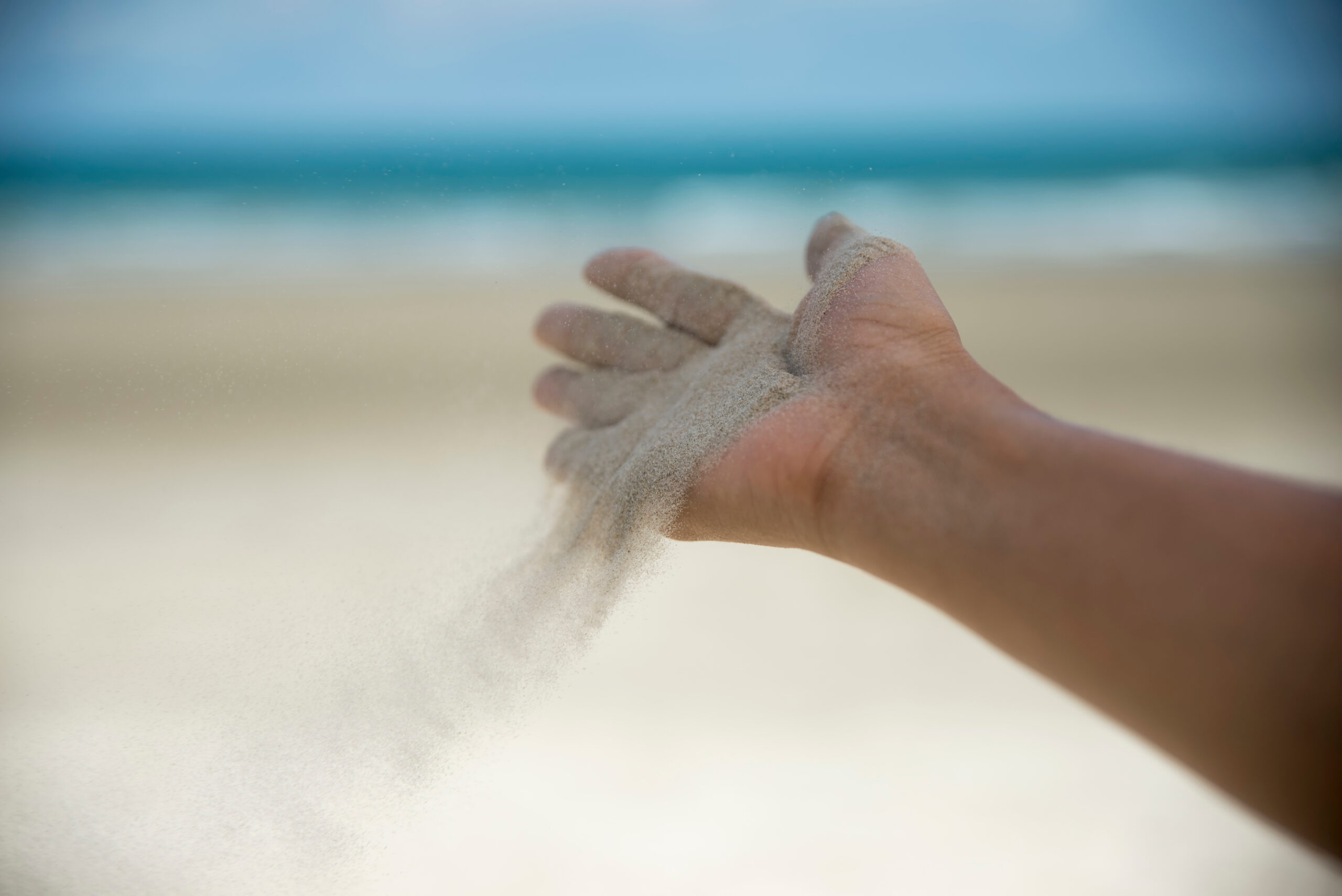 Main ouverte laissant s'envoyer du sable au vent