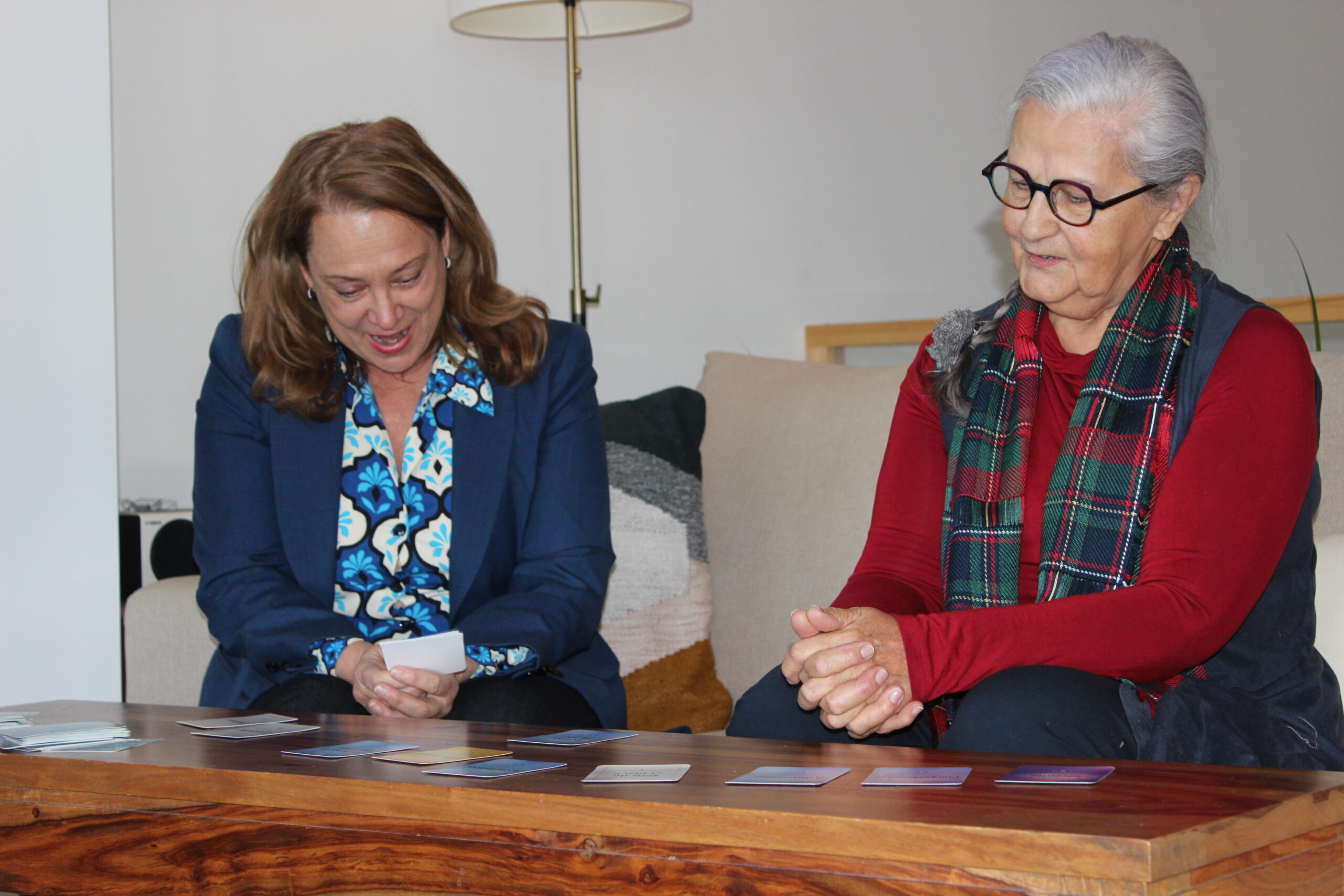 Deux femmes regardent des cartes étalées devant elles.