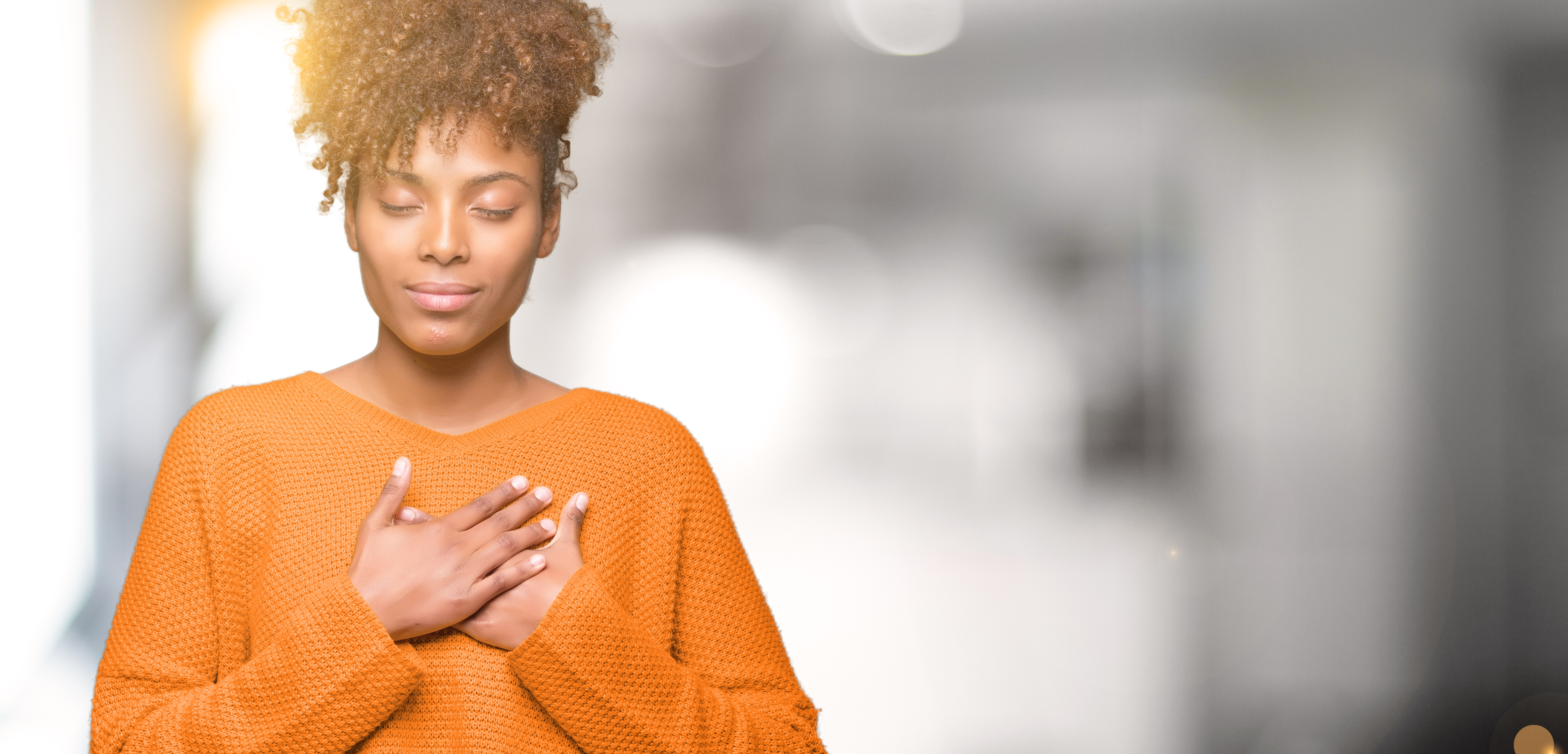 Femme, yeux fermés, deux mains croisées sur le coeur