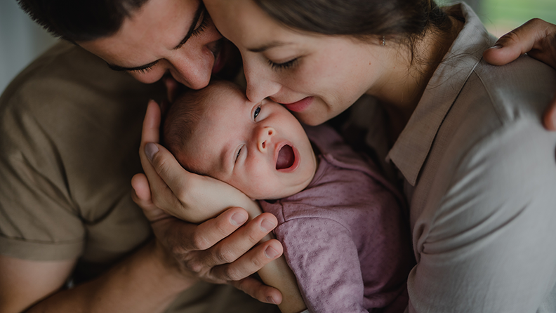 Un homme, une femme et un bébé enlacés