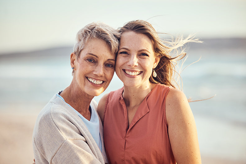 Deux femmes souriantes, enlacées, regardant devant