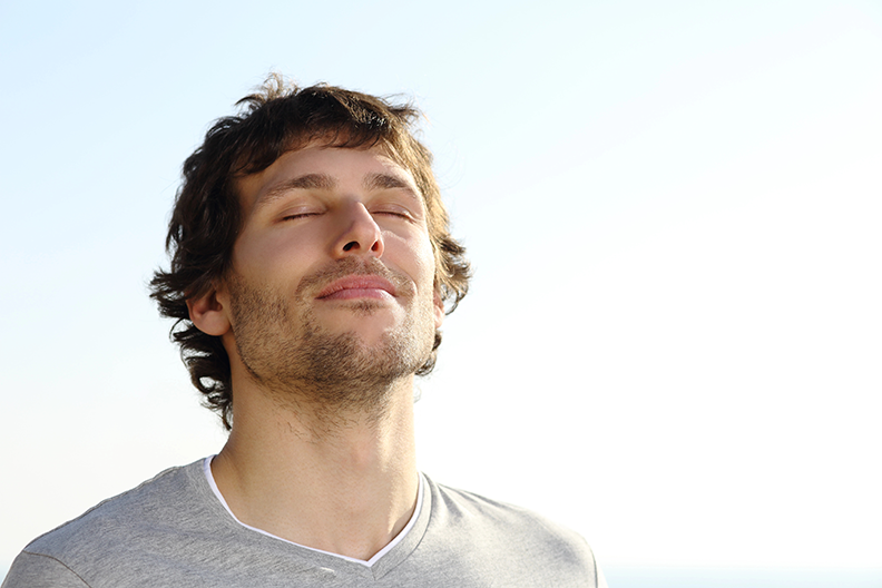 Jeune homme, yeux fermés, visage levé vers le ciel