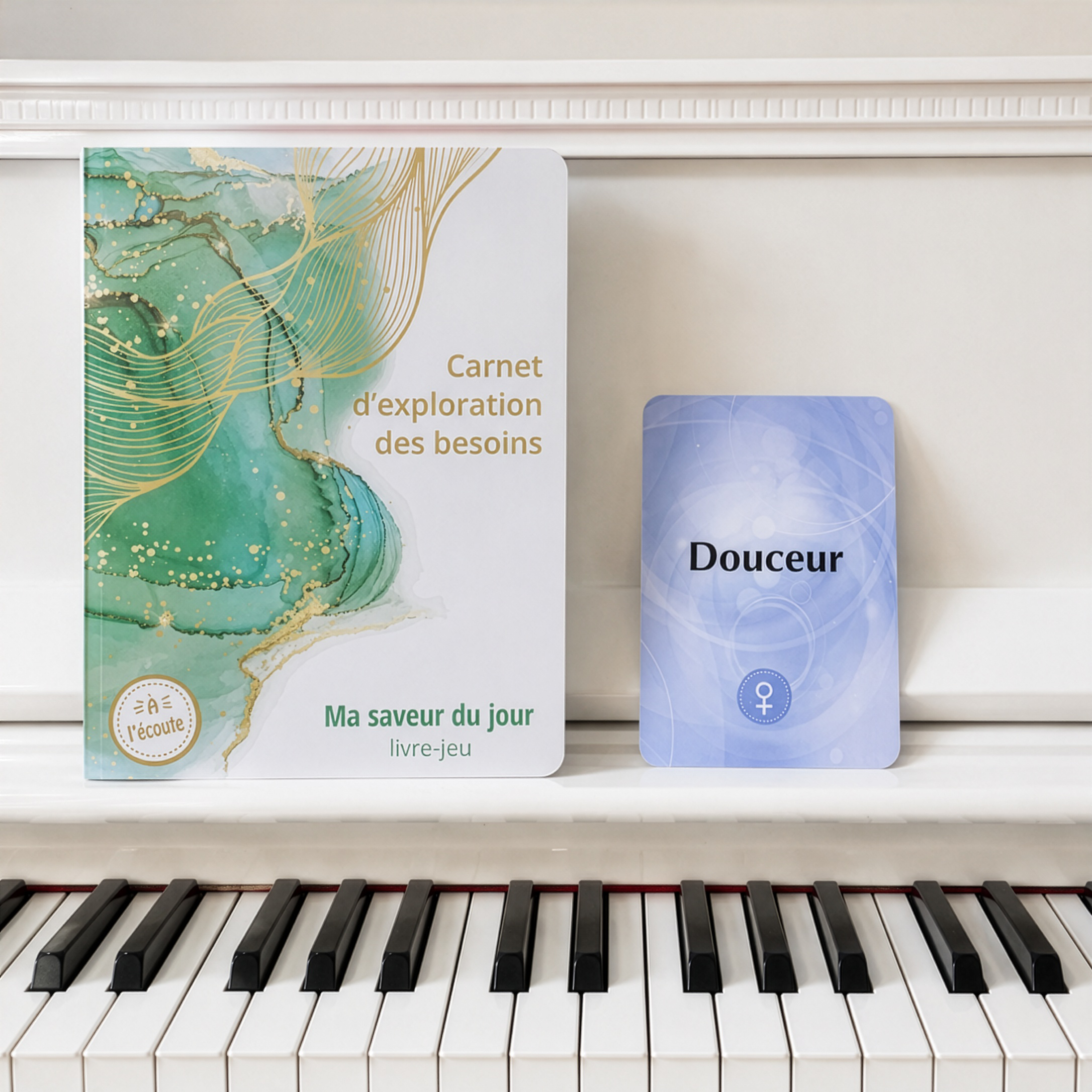 Le Carnet d'exploration des besoins à côté de la carte DOUCEUR posés sur un piano